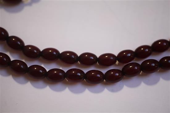 Two single strand red simulated amber bead necklaces, largest 158cm.